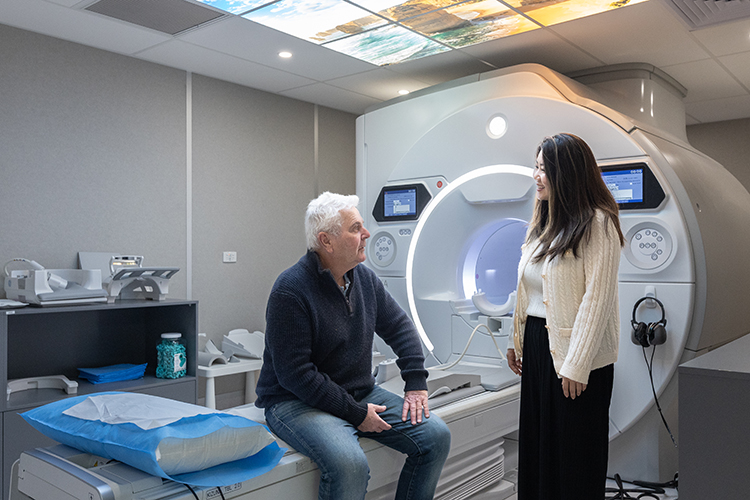 Person preparing for an MRI scan with guidance from an imaging professional