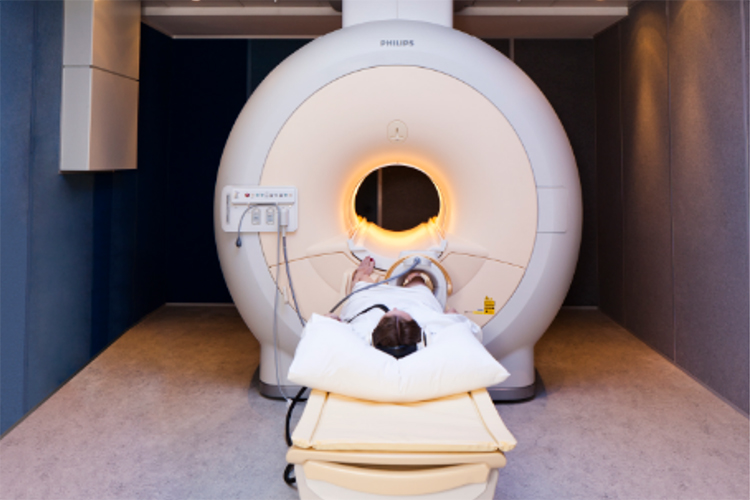 Female patient lying on the bed of an MRI machine